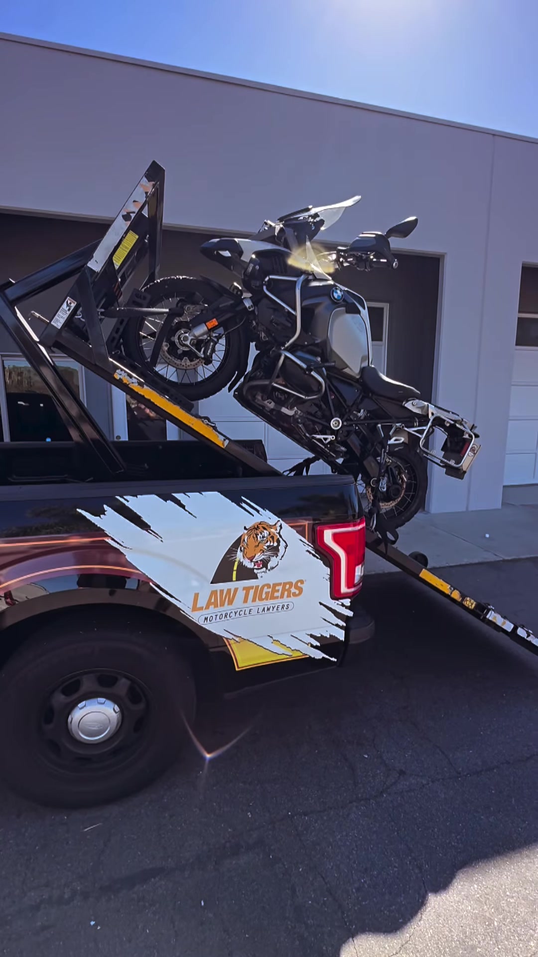 BMW adventure bike loading on Law Tigers black truck lift